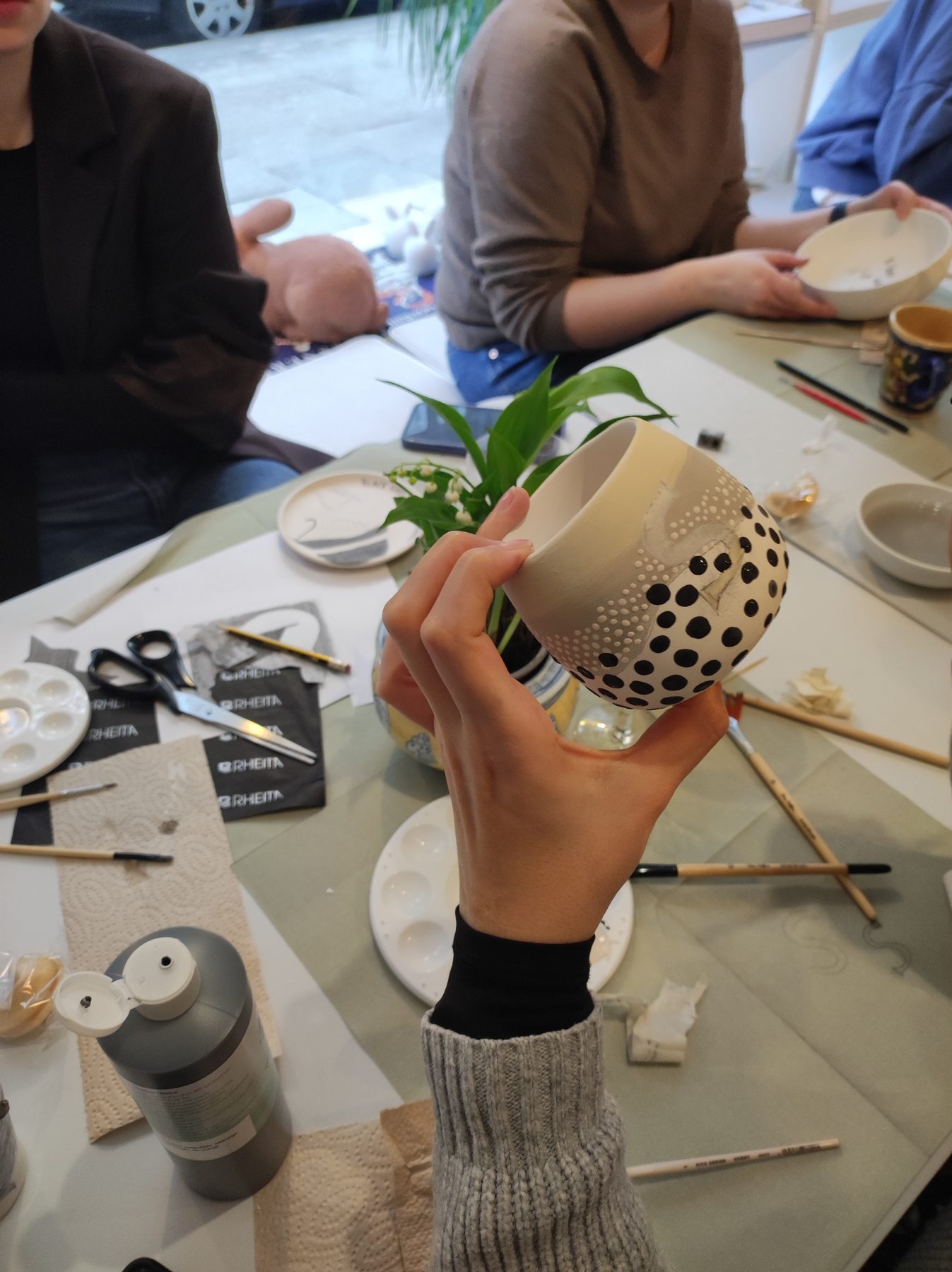 Tisch mit Keramikfarben und Pinseln im Kreativstudio
